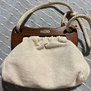 FS Originals purse with wooden opening and woven strap. Satin liner.